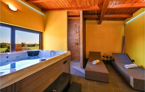a bathroom with a tub with two chairs and a window at Beautiful Home In Brezane Lekenicke With Sauna 