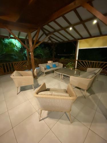 a patio with couches and a table and chairs at Villa panoramique à Pointe-Noire avec vue sur mer et piscine in Pointe-Noire