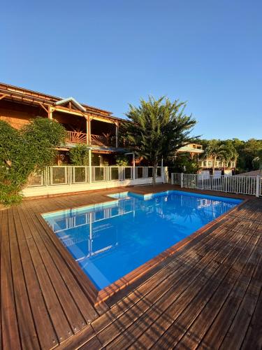 a large swimming pool on a wooden deck at Appartement charmant à Pointe-Noire, vue mer, 51 m², piscine in Pointe-Noire