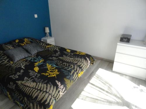 a bedroom with a bed with a black and yellow blanket at Gite L ABRI COSTIER in Villeveyrac