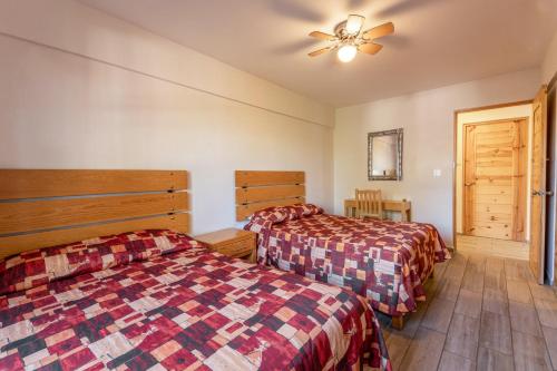 a bedroom with two beds and a ceiling fan at Hotel Meson de Sara in Querétaro