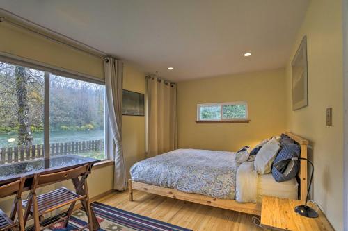 a bedroom with a bed and a large window at Riverfront Gold Bar Cabin with Hot Tub and Mtn Views! in Gold Bar