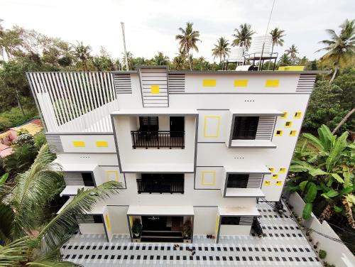 an aerial view of a white building with yellow squares at Happy Buddha S4 in Varkala
