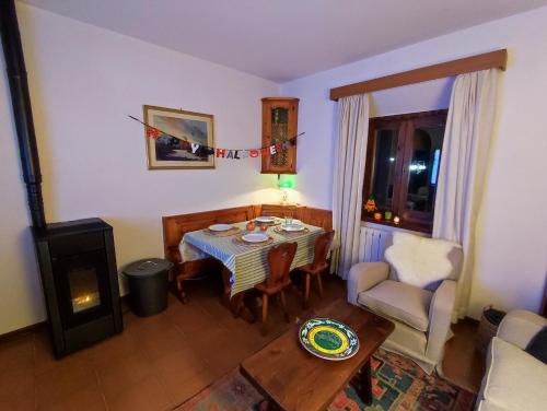 ein Wohnzimmer mit einem Tisch und einem Stuhl in der Unterkunft Appartamento Belvedere Abetone in Abetone