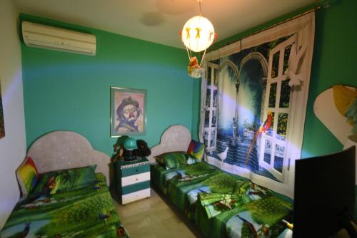 two beds in a room with green walls at Villa Panorama, now a Smart Home in Skala Kallirakhis