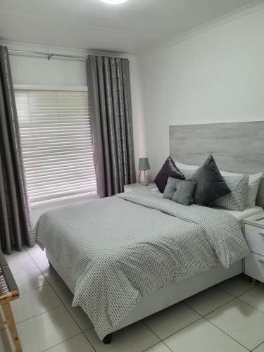 Un dormitorio blanco con una cama grande y una ventana en Overport Durban Halaal Accommodation "No Alcohol Strictly Halaal No Parties" Entire Luxury Apartment, 2 Bedroom, 4 Sleeper, Self Catering, 300m from Musjid Al Hilaal en Durban