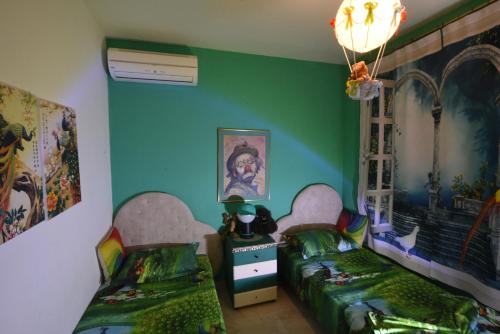 two beds in a room with green walls at Villa Panorama, now a Smart Home in Skala Kallirakhis
