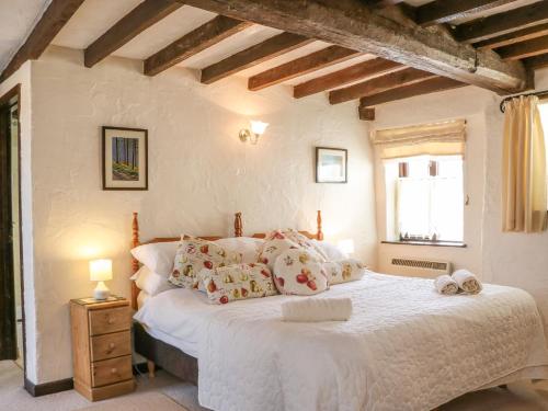 a bedroom with a large white bed with pillows at Pillhead Cider House in Bideford