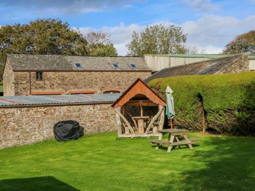a tent and a picnic table in front of a building at Pillhead Cider House in Bideford