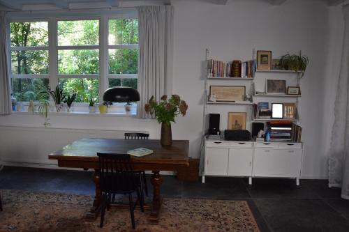 a living room with a wooden table and a window at Villa Conti in Dordrecht