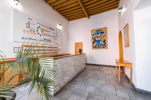 ein Restaurant mit einer Wand mit einer Theke und einer Pflanze in der Unterkunft Hotel Meson de Carolina in Querétaro