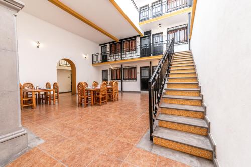 Hotel Meson de Carolina في كيريتارو: درج في غرفة مع طاولة وكراسي