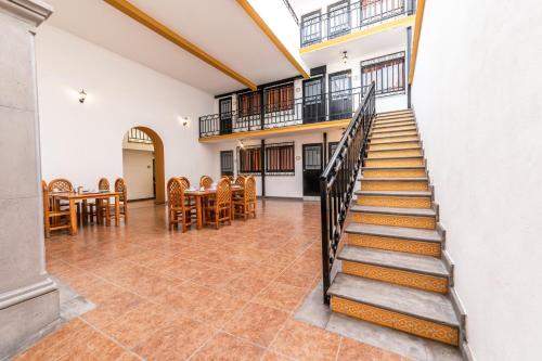 een trap in een kamer met een tafel en stoelen bij Hotel Meson de Carolina in Querétaro