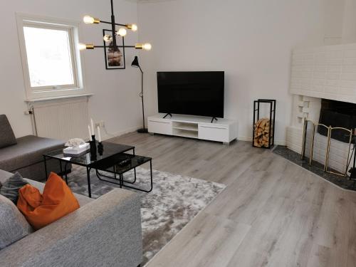 a living room with a couch and a flat screen tv at The Red and White House in Luleå