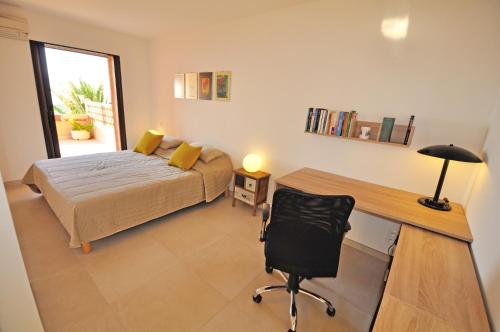 - une chambre avec un lit, un bureau et une chaise dans l'établissement Les Terrasses du Pano - 76 m2 au calme - Jardin - Barbecue - Transats - Pleine vue mer - Wifi Fibre, à Porticcio