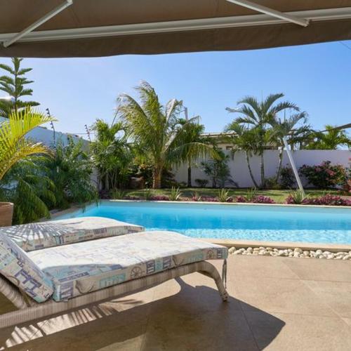 ein Bett auf einer Terrasse neben einem Pool in der Unterkunft Villa Primera 3 bedroom bungalow with private pool Grand Bay in Grand Baie