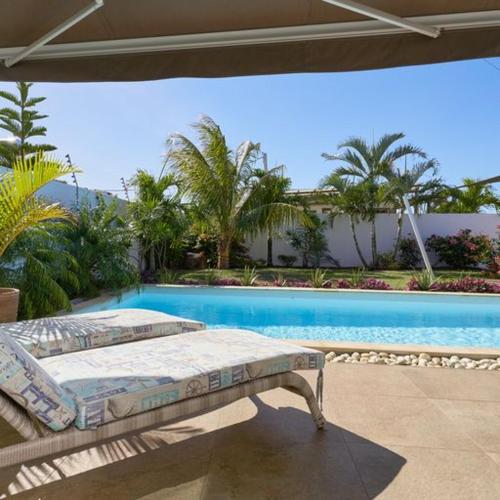 a bed sitting on a patio next to a swimming pool at Villa Primera 3 bedroom bungalow with private pool Grand Bay in Grand Baie