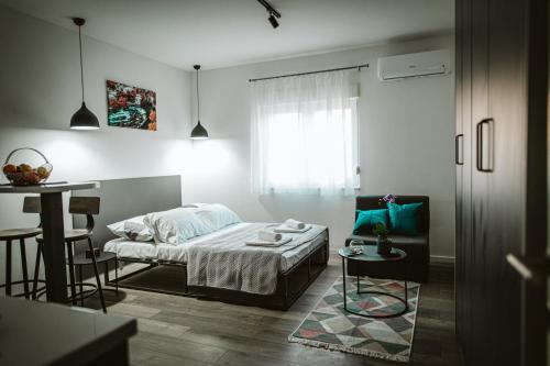 a bedroom with a bed and a table and a chair at Hercegovina apartments in Mostar