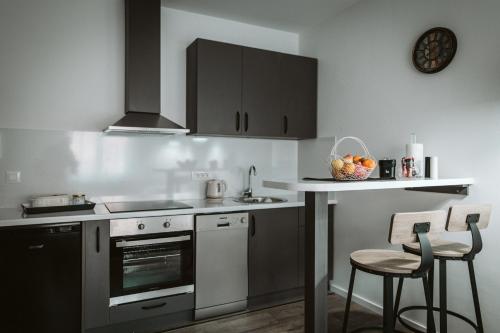 a kitchen with stainless steel appliances and a bowl of fruit on the counter at Hercegovina apartments in Mostar