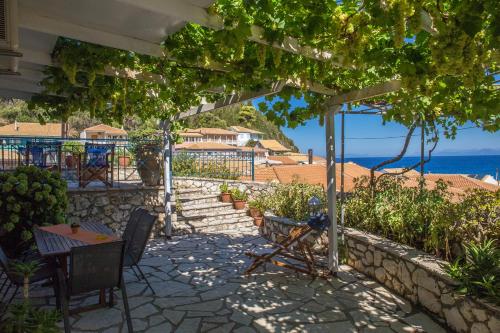 a patio with a table and chairs and a view of the ocean at Pantazis Studios in Agios Nikitas in Agios Nikitas
