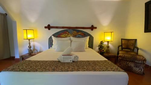 1 dormitorio con 1 cama grande con 2 lámparas y 1 cama sidx sidx en Bambuddha Centro Holistico, en Barra Vieja