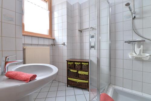 a white bathroom with a tub and a sink at S'Harzala Rouge in Bergheim