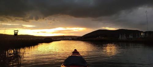 a kayak on a river with a sunset in the background at Q'OTA TAYPY LODGE in Puno