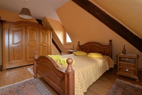 1 dormitorio con cama de madera y almohadas amarillas en S'Harzala Jaune, en Bergheim