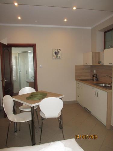 a kitchen with a table and chairs and a sink at Apartamenty Lawenda in Rabka
