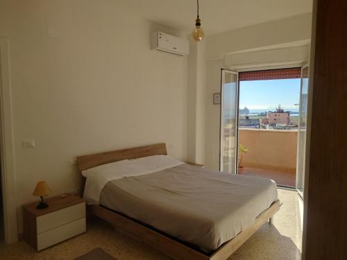 a bedroom with a bed and a door to a balcony at Casa Flegrea Bagnoli in Naples