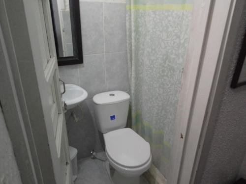La petite salle de bains est pourvue de toilettes et d'un lavabo. dans l'établissement Hotel El Dorado La Candelaria, à Bogotá