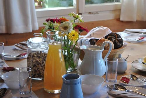 a table with flowers and a jug of orange juice at Großzügige Ferienwohnung am Skigebiet Bödele mit Rheintalblick in Dornbirn