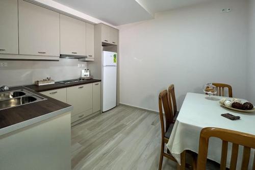 eine Küche mit einem Tisch und einem weißen Kühlschrank in der Unterkunft House33 in Kalambaka