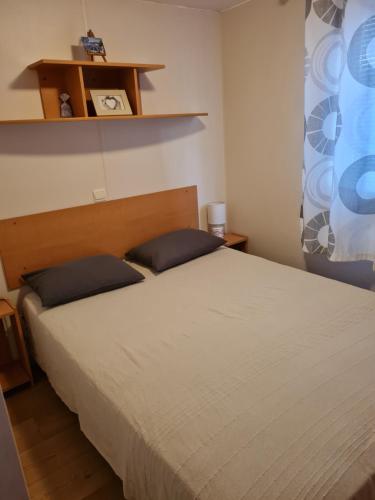 a bedroom with a bed with two pillows on it at Mobilhome 6personnes camping oasis village 5 etoiles in Puget-sur-Argens