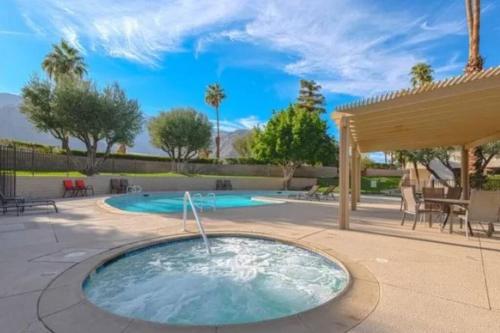 a hot tub in a patio with a gazebo at Perfect Palm Springs Pied-à-terre in Palm Springs