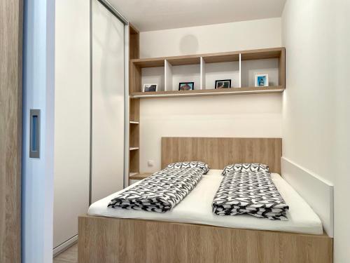 uma cama num pequeno quarto com prateleiras em Top KamzikTower View em Bratislava