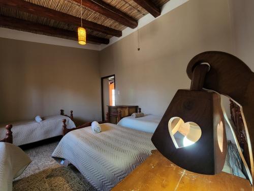 a bedroom with two beds and a heart shaped mirror at HOSPEDAJE LA CASONA DE CACHI in Cachí