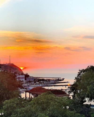 a sunset over a harbor with the sun setting in the background at Vistamar Duplex in Lima
