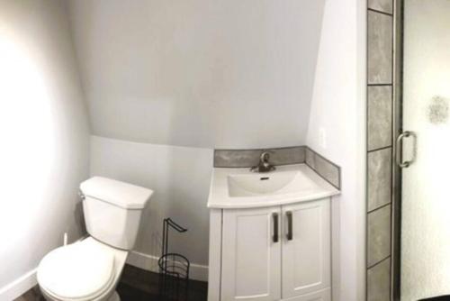 Łazienka z białą toaletą i umywalką w obiekcie Rustic 1-Bedroom farm style loft with fire pit w mieście Cobble Hill