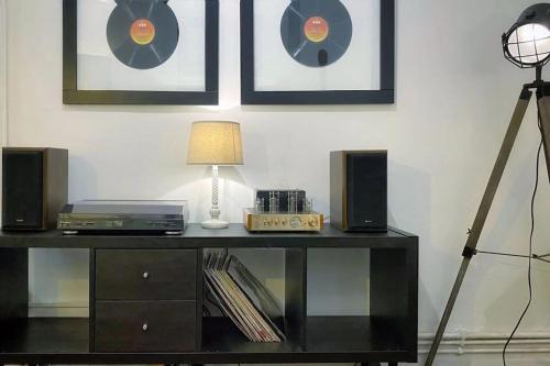 a room with a table with a lamp and speakers at Urban Music Style Townhouse in Swansea city center in Swansea