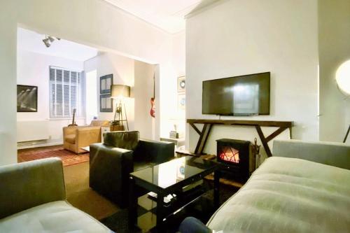 a living room with a couch and a fireplace at Urban Music Style Townhouse in Swansea city center in Swansea