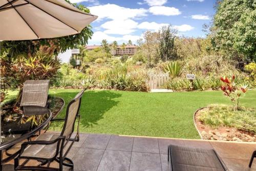 un patio con sedie e un ombrellone e un cortile di Kiahuna Plantation Unit 320 - Ground Floor Garden View, Air Conditioning a Koloa