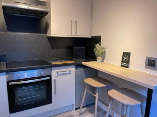 a kitchen with a counter and a stove and stools at Pedlars Rest in Swaffham