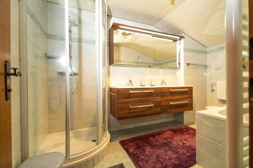 a bathroom with a shower and a sink and a mirror at Haus Anton Sölden - Apartments & Zimmer in Sölden