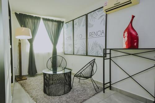 a living room with a table and a chair at Hotel Florencia Poza Rica in Poza Rica de Hidalgo