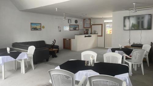 a living room with tables and chairs and a couch at Coco Cottage Local Style in Guraidhoo