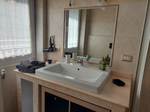 a bathroom with a white sink and a mirror at Appartamento centrale in Lido di Ostia