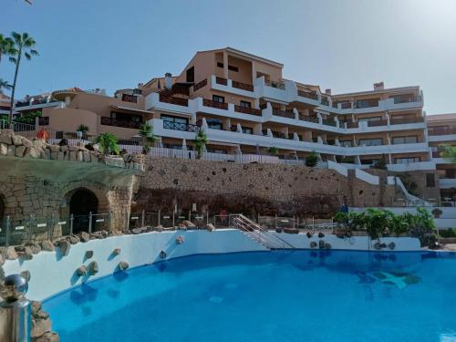 un hotel con piscina di fronte a un edificio di Ocean Breeze Albatros a San Miguel de Abona