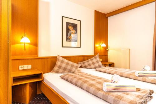 a hotel room with two beds and a woman at Haus Anton Sölden - Apartments & Zimmer in Sölden