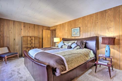 a bedroom with a large bed and wooden walls at Retro Rhinelander Lake Retreat with Fire Pit! in Rhinelander
